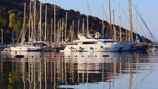 Sailboats and yachts in the evening. Beautiful reflection in sea water. Marine travel lifestyle.