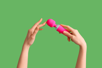 Woman with pink vibrator from sex shop on green background
