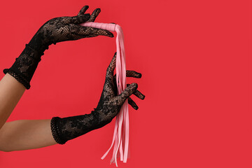 Fototapeta premium Woman with pink whip from sex shop on red background