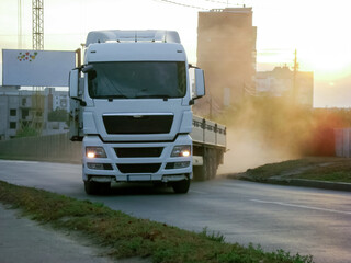 A truck pulls out onto the road.On the left is a house under construction and a blank banner with...