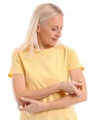 Mature diabetic woman giving herself insulin injection on white background