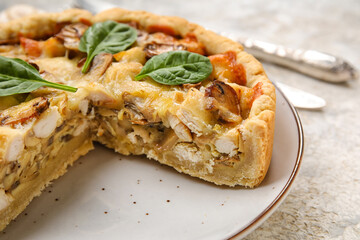 Mushroom pie with spinach leaves and cutlery on white grunge table