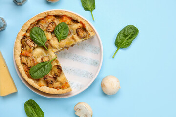 Mushroom pie with spinach leaves and champignons on blue background