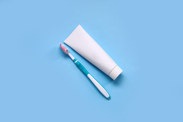 Plastic toothbrushes and paste on blue background