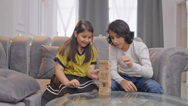 Serious Indian kids playing Jenga at home