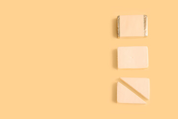 Sliced processed cheese on yellow background