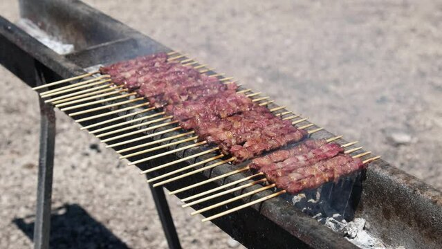 italian kebabs skewers called Arrosticini abruzzese from the Italy region Abruzzo made by lamb meat on grill 
