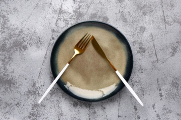 Plate with cutlery on grunge grey background