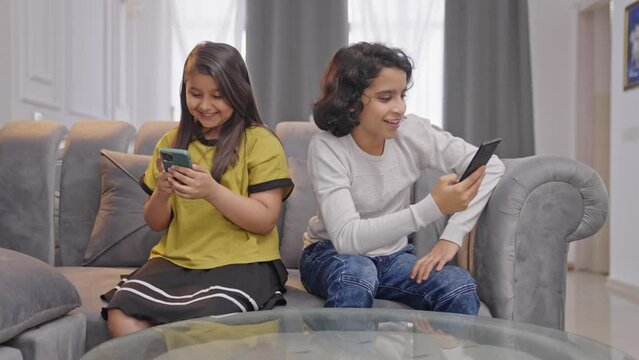 Happy Indian kids busy with their phones and not talking to each other