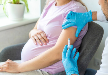 A pregnant woman makes a vaccination. Selective focus. - obrazy, fototapety, plakaty
