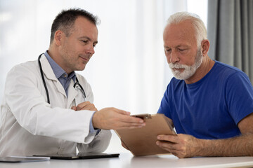 Senior man filling insurance or other legal document at appointment with doctor. Elderly patient signing medical treatment contract, agreement form for medical care service, consultation, therapy