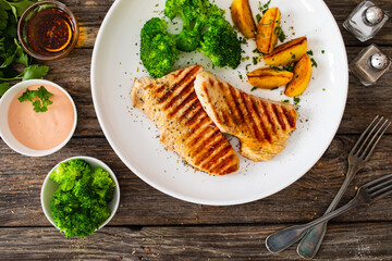Barbecued turkey breast and broccoli on wooden table 
