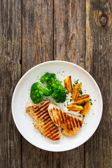 Barbecued turkey breast and broccoli on wooden table 