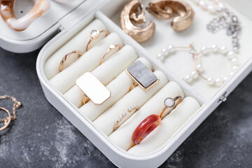 Organizer with stylish jewelry on dark grunge background