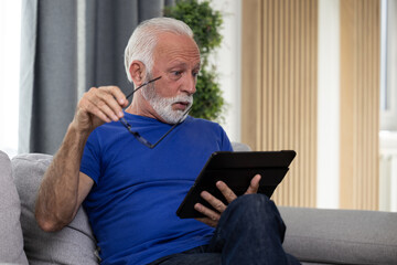 Shocked frustrated senior mature man reading shocking online news at home. Stressed worried elderly male confused by bad news or computer problem - 602222512