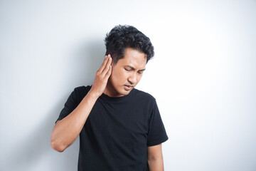 Asian man wearing black t shirt with earache is holding his aching ear body pain concept