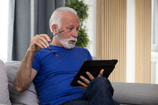 Shocked frustrated senior mature man reading shocking online news at home. Stressed worried elderly male confused by bad news or computer problem