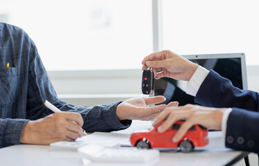 The young businessman made a lease for a new car in the office of a car dealer and received the keys after the contract was completed. The concept of a car purchase contract
