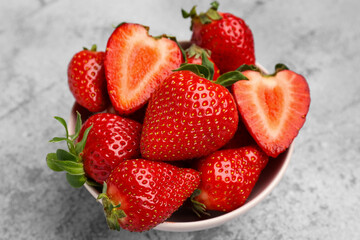 Bowl of fresh strawberries on grey grunge background