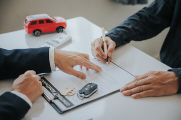 Closing sale. Asian customer signing car insurance paperwork or lease contract or agreement. Buy or...