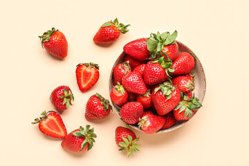 Bowl of fresh strawberries on beige background