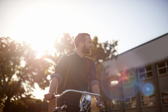 Bicycle, travel and man with lens flare happy for exercise, commute and cycling in morning. Transport, city and male cyclist with bike for eco friendly traveling, carbon footprint ride and journey
