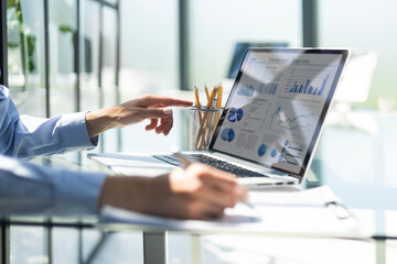 Young businessman typing computer laptop with graph chart for work