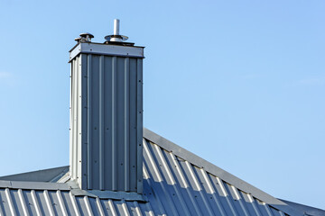 Obraz premium A tinned chimney with a metal insert on the background of the sky