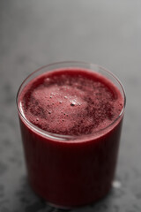 Glass of berry juice on concrete countertop