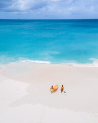 Couple Kayaking in the Ocean on Vacation Aruba Caribbean Sea, man and woman mid age kayak in ocean blue clear water with white beach and palm trees Aruba