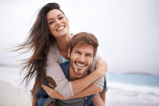 Hug, beach and portrait of couple piggyback with love, smile and laugh while bonding outdoor. Face, embrace and happy man with woman at the ocean for travel, freedom or vacation, holiday or Bali trip