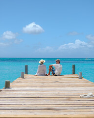 a couple of men and women on a wooden pier in the ocean near Palm Beach Aruba Caribbean,