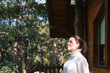 relaxed and happy woman enjoying nature in a treehouse in the middle of the forest
