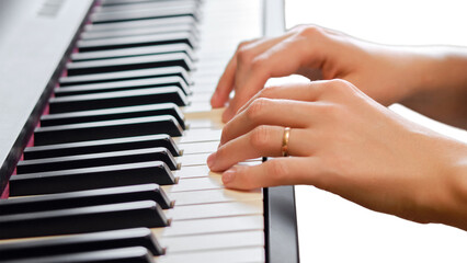 Fototapeta na wymiar An adult woman plays an electric piano, hands close-up, isolated on white background. Female hands on the keys of a portable electronic piano