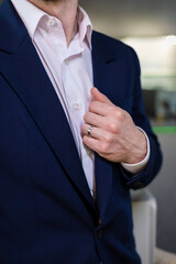 Close up portrait of a glamorous man in a stylish suit with a ring on his hand. A modern man with a...