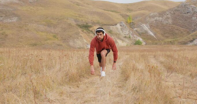 handsome man in sportswear starting a race for running on field Active bearded male spending free time for regular training on fresh air outdoor. Man is Concentrate and breath.