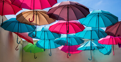 Fototapeta na wymiar umbrellas colored like the rainbow fly free towards the sky