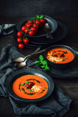 Fototapeta na wymiar Fresh tomato soup with roasted tomatoes, feta cheese and basil pesto