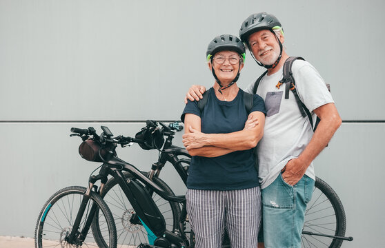 Happy caucasian senior couple enjoying sport activity with their electric bicycles - healthy active lifestyle during retirement