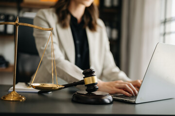 justice and law concept.law theme wooden desk, books, balance. Male judge in a courtroom the gavel,working with digital tablet computer