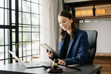 Beautiful Caucasian woman lawyer working and gavel, tablet, laptop in front, Advice justice and law concept. in office