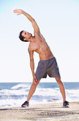 Fototapeta na wymiar Fitness, man and stretching body on beach getting ready for exercise, workout or training in nature. Fit, active or muscular male exercising in warm up stretch for healthy cardio or wellness by ocean