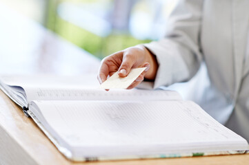 Woman, hands and credit card with book for payment, transaction or purchase for appointment or reservation. Hand of female showing debit at reception to buy, pay or shopping for booking or check in