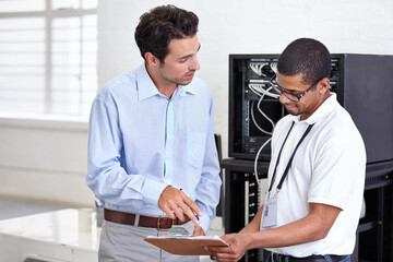 Server room, clipboard and discussion with a technician talking to a business man about a cyber security contract. Network, database and documents with a male engineer chatting about an agreement