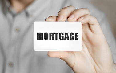 Card with text mortgage in a man's hand