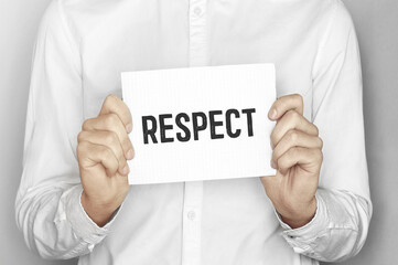 Man holding a paper card with text respect