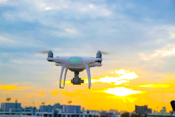 Delivery drone flying over city building sunset sky cloud