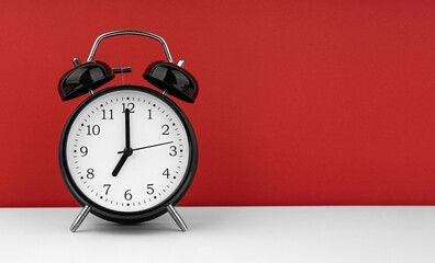 Black alarm clock on a red background