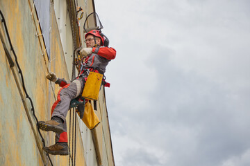 Obraz premium Rope access is a high-risk job. A man works on ropes.