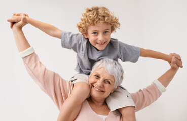 Portrait, airplane and grandmother with child embrace, happy and bonding against wall background....